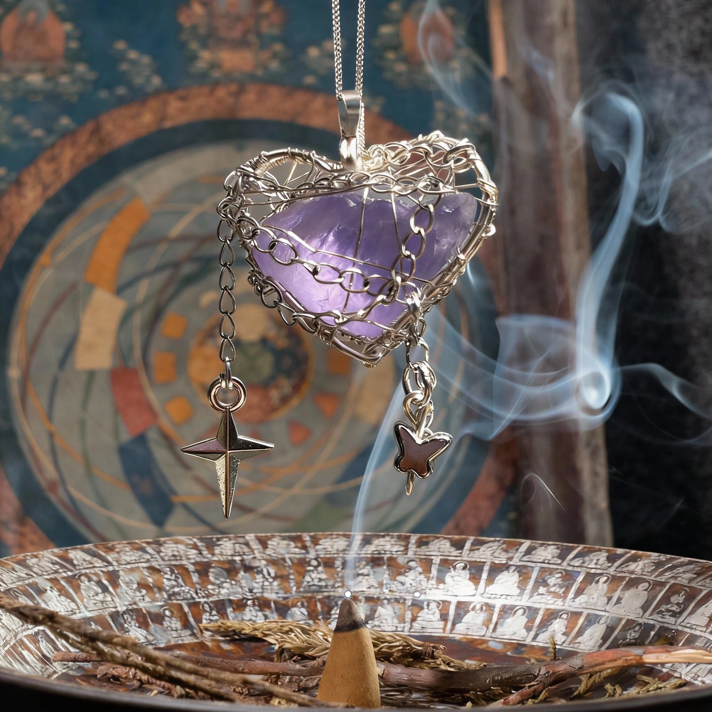 Pendant suspended above an incense burner with decorative backdrop and curling smoke.